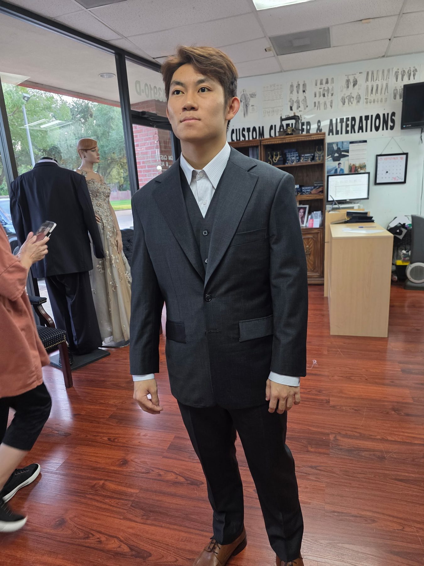 Same client wearing the finished three-piece suit, fully constructed, at GM Custom Clothier in Sugar Land, TX
