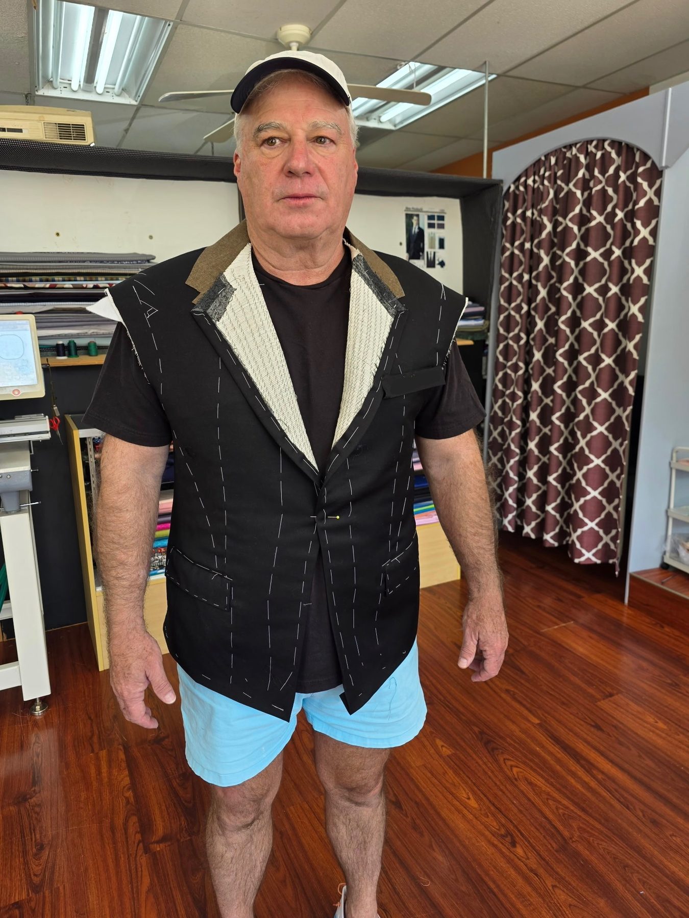 Another client mid-fitting in a hand-basted jacket, raw canvas visible, at GM Custom Clothier in Sugar Land, TX