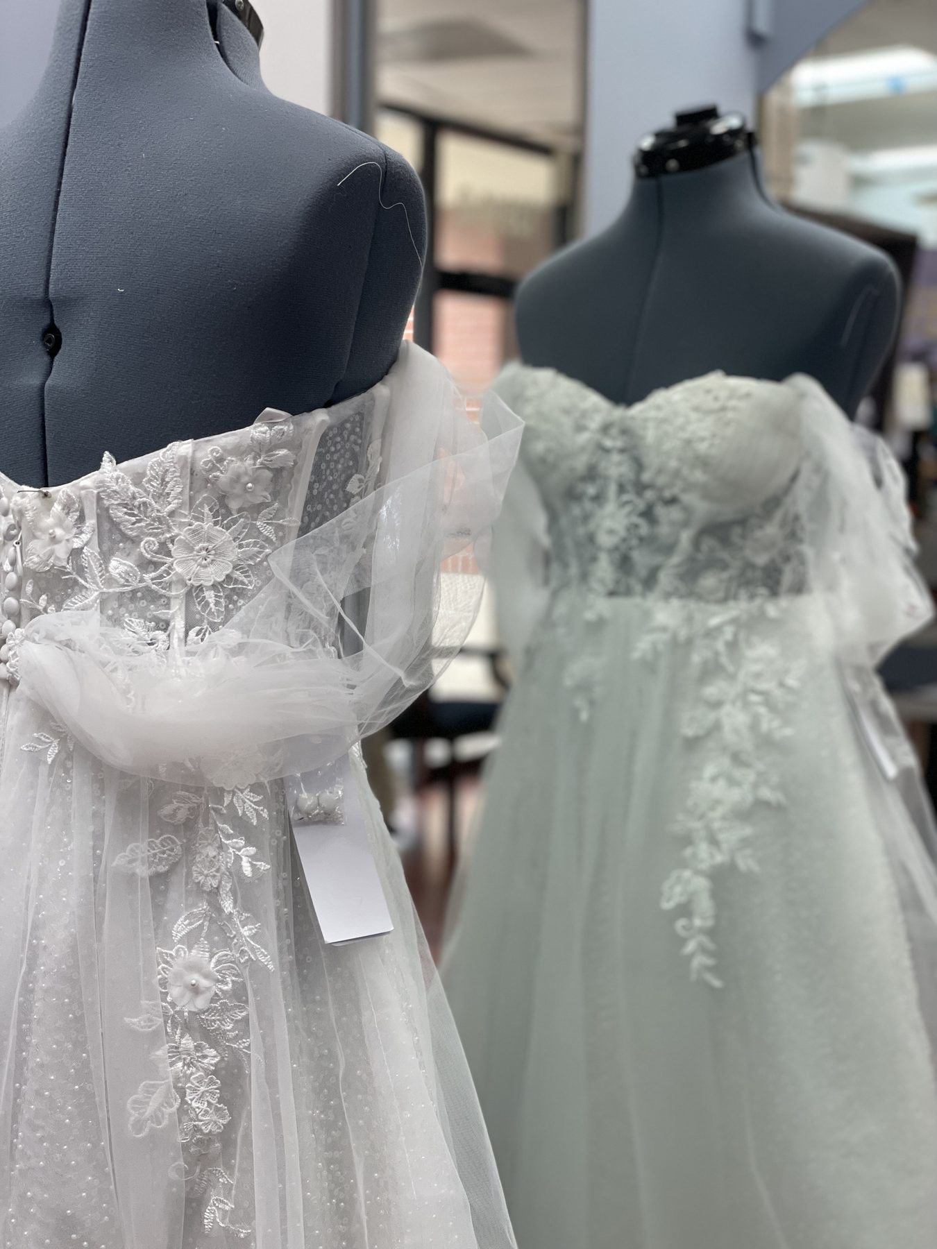 Two bridal gowns with lace detailing, fresh from fitting
