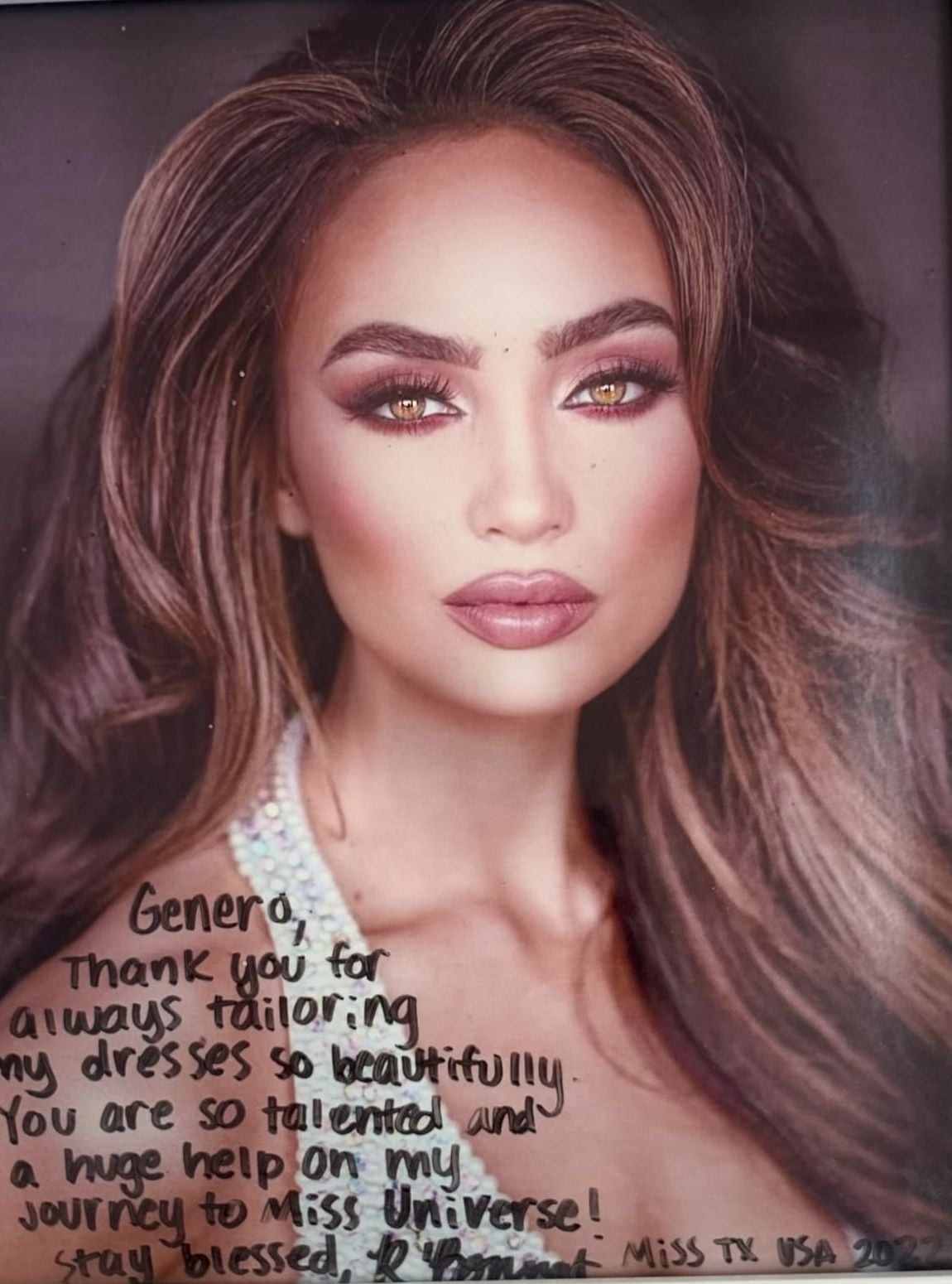 Photo of Miss Texas USA and Miss Universe 2022 R'Bonney Gabriel with a handwritten thank-you note to GM Custom Clothier for her gown alterations